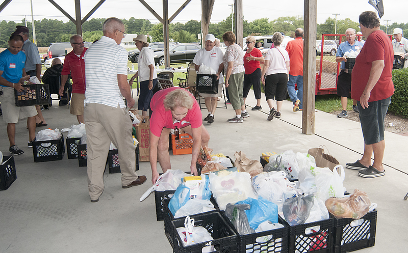 Volunteers load the pantry goods during the food drive. BY DENY HOWETH